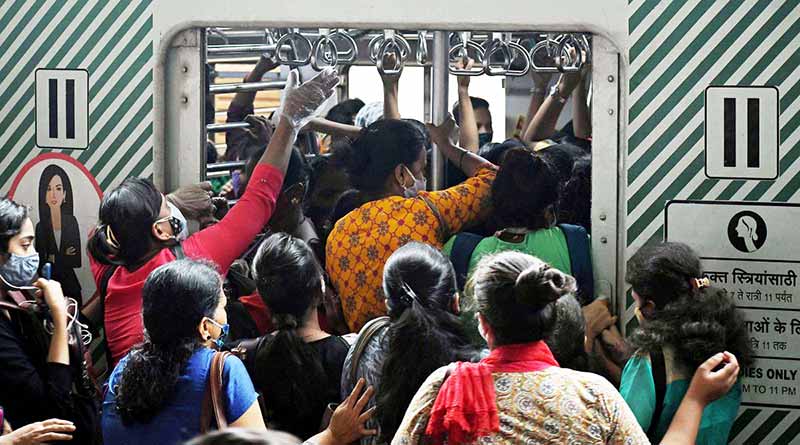 Women rushing into a crowded apartment of a suburban train in Mumbai
