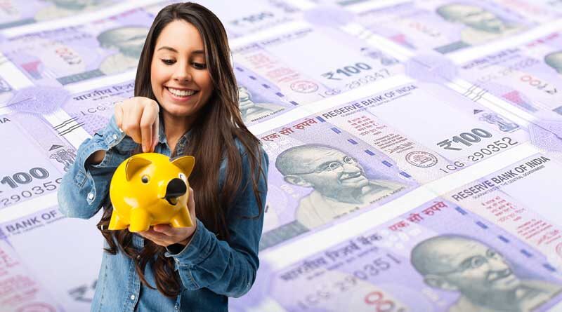 Young girl putting money into a piggy bank