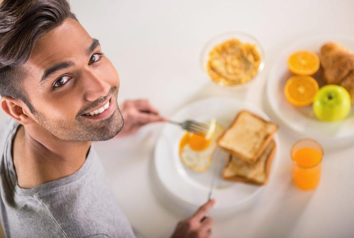Young man eating breakfast