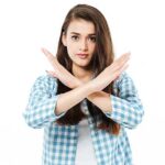 Young woman crossing her hands in no sign