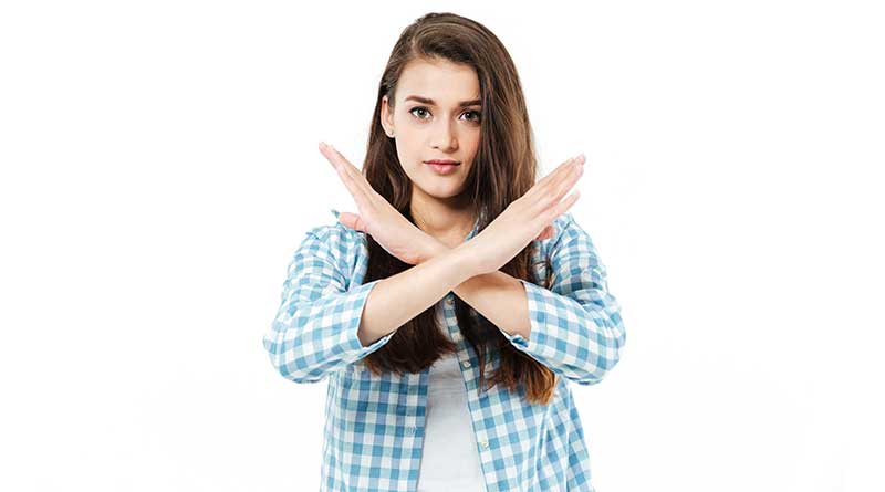 Young woman crossing her hands in no sign