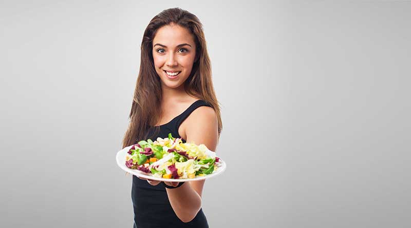 Young woman holding plate of salad