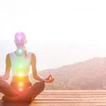 Young woman meditating on wooden platform