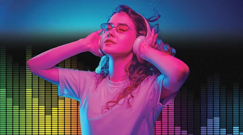 Young woman listening to music on the headphones