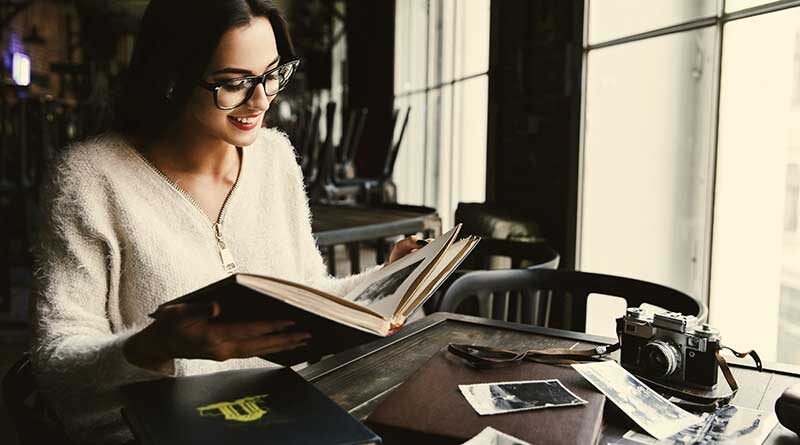 Young woman looking at old photos and reliving memories of the past