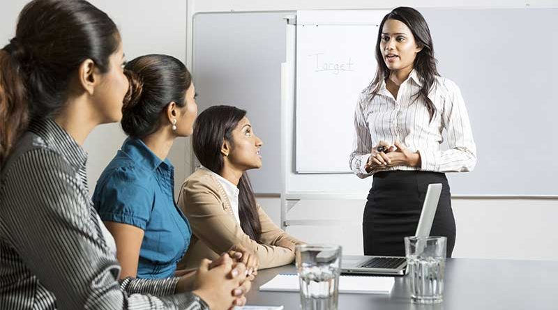 A young woman giving a presentation to three other women