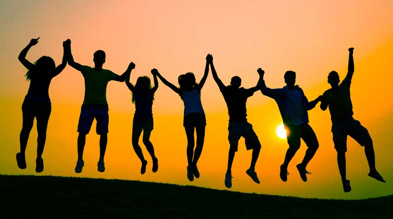 Silhouettes of youth jumping at sunset