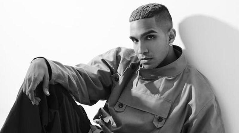 Yung Raja sitting down and leaning against a wall