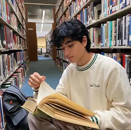 Teenager reading book in a library