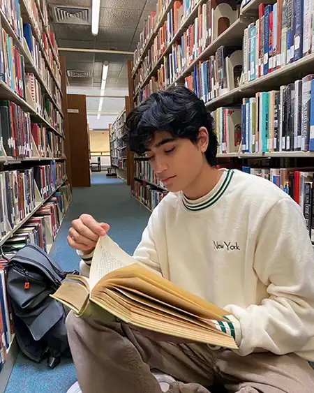 Teenager reading book in a library