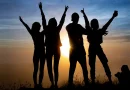 Silhouette of friends with arms in the air