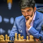 Gukesh Dommaraju staring at the chess pieces on a chess board