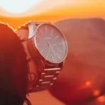 Wristwatch on man's hand at sunset
