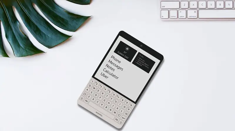 Minimal Phone on a desktop near keyboard and a plant