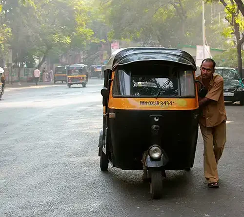 Rickshaw driver pushing his rickshaw on the road