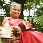 Sudha Murty sitting with an open book on her lap