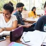 Young people studying and writing while seated at desks